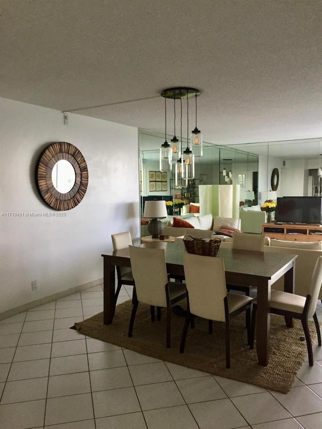 dining space featuring light tile patterned floors and a textured ceiling