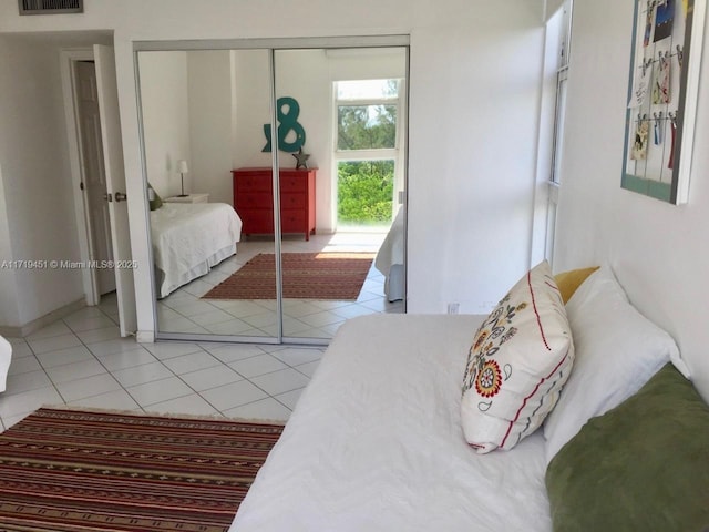 bedroom featuring light tile patterned flooring and a closet