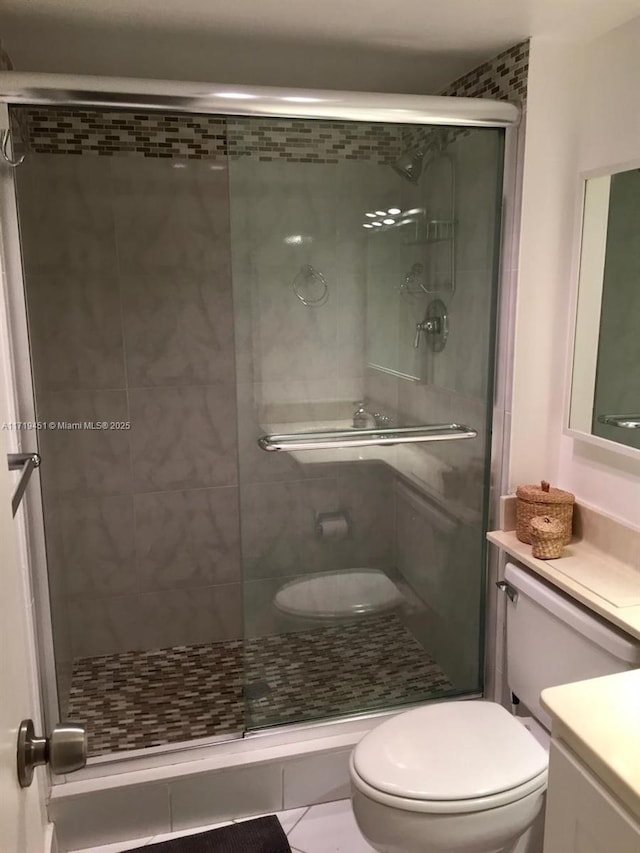 bathroom with tile patterned flooring, vanity, toilet, and an enclosed shower