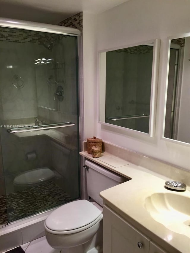 bathroom featuring vanity, toilet, and an enclosed shower