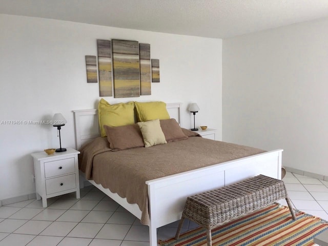 bedroom with light tile patterned floors and a textured ceiling