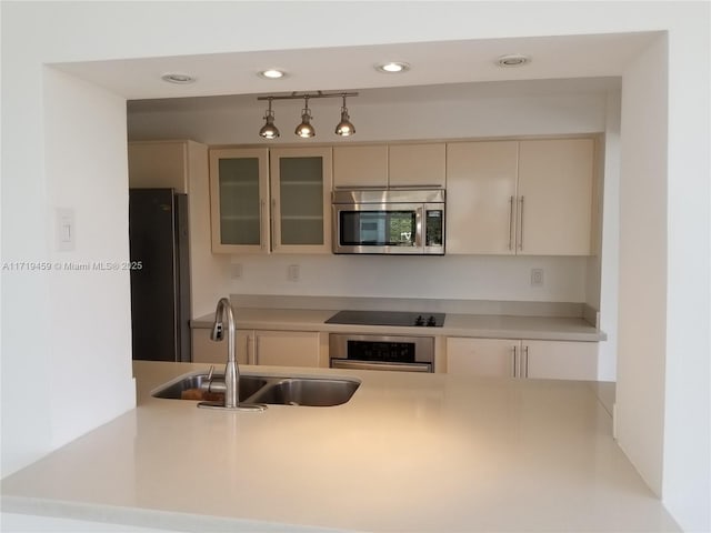 kitchen featuring cream cabinetry, sink, and appliances with stainless steel finishes