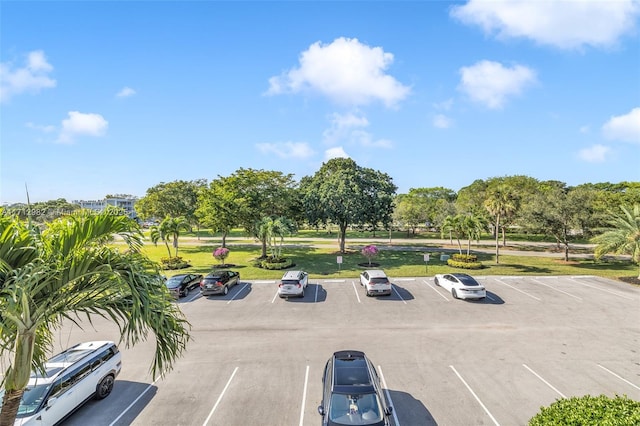 3003 Lyndhurst H Unit 3003, Deerfield Beach, FL 33442 - uncovered parking lot featuring view of wooded area