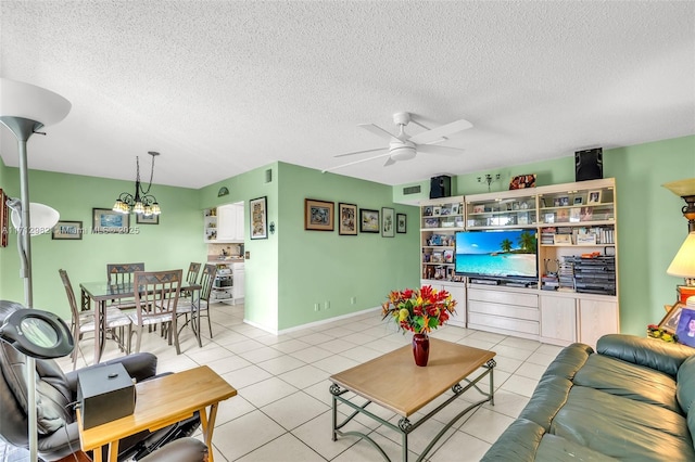 tiled living room with a textured ceiling and ceiling fan with notable chandelier