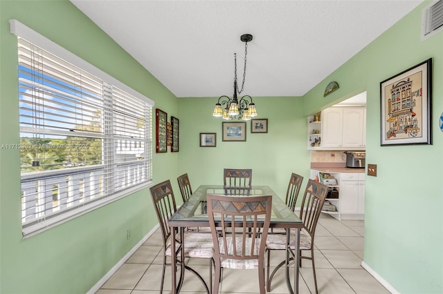 tiled dining room featuring an inviting chandelier