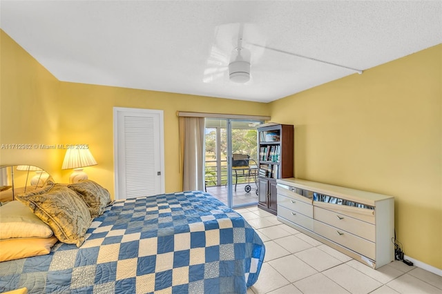 bedroom with ceiling fan, access to exterior, light tile patterned floors, a textured ceiling, and a closet