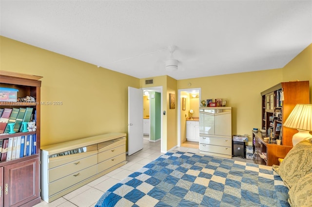 tiled bedroom with ceiling fan and connected bathroom