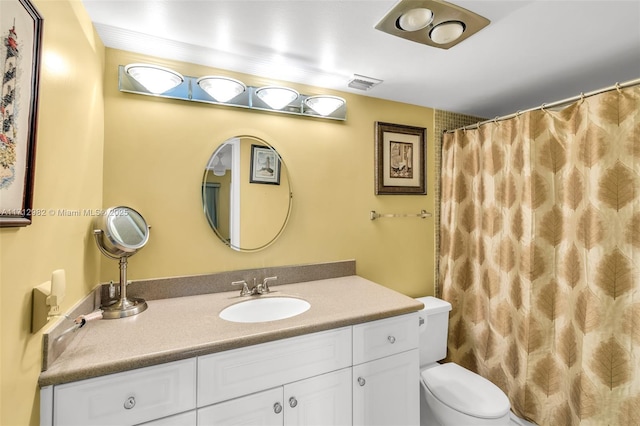 bathroom featuring vanity, toilet, and walk in shower