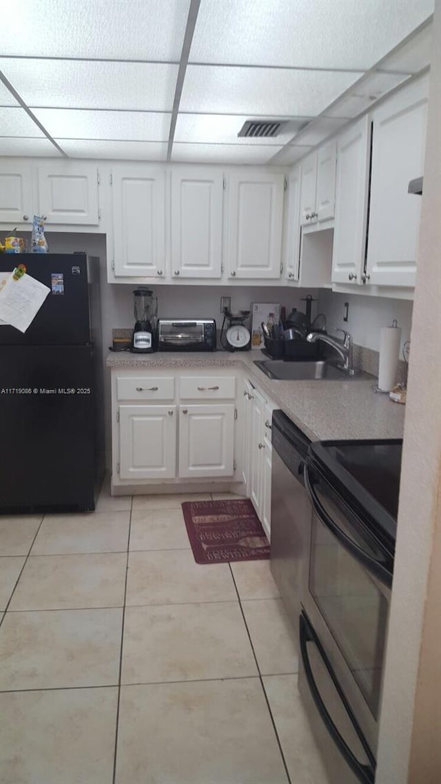 kitchen featuring light tile patterned flooring, sink, white cabinets, and black appliances