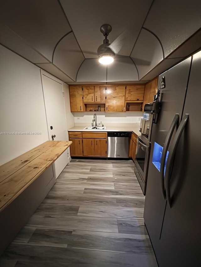 kitchen featuring butcher block countertops, sink, light hardwood / wood-style floors, and appliances with stainless steel finishes