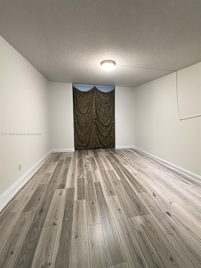 unfurnished room featuring a textured ceiling and hardwood / wood-style flooring