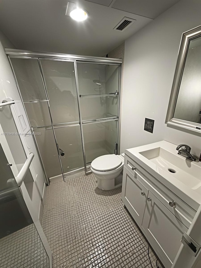 bathroom featuring tile patterned floors, walk in shower, vanity, and toilet