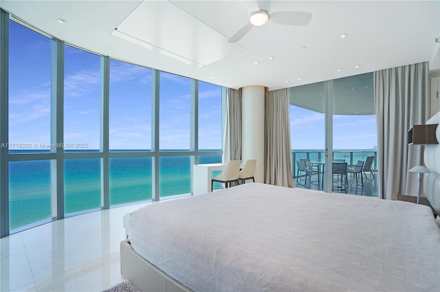 bedroom featuring floor to ceiling windows, multiple windows, a water view, and ceiling fan