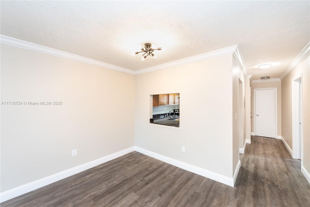 spare room featuring crown molding, dark hardwood / wood-style flooring, and a textured ceiling