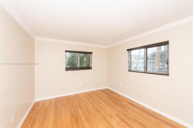 empty room with hardwood / wood-style floors and crown molding