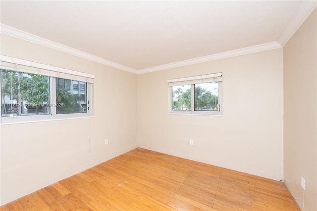 unfurnished room featuring light hardwood / wood-style floors, a healthy amount of sunlight, and ornamental molding