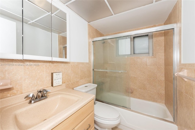 full bathroom featuring decorative backsplash, bath / shower combo with glass door, vanity, tile walls, and toilet