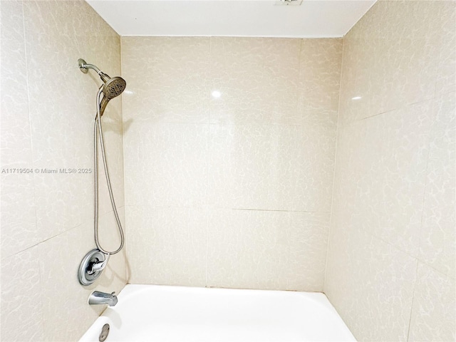 bathroom featuring tiled shower / bath