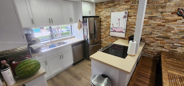 kitchen with light hardwood / wood-style floors, white cabinetry, sink, and appliances with stainless steel finishes