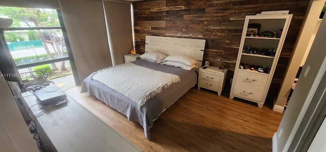 bedroom with wood walls and hardwood / wood-style flooring