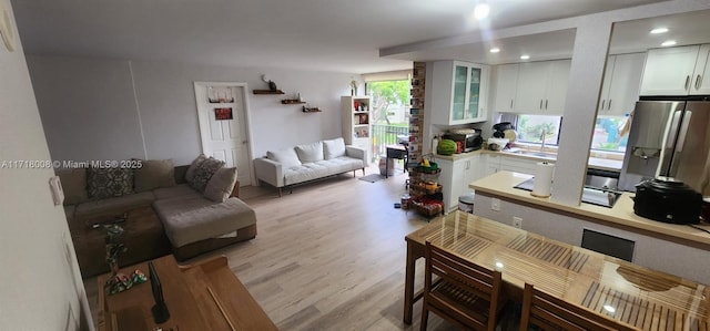 living room with sink and light hardwood / wood-style flooring