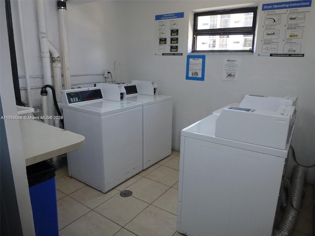 washroom featuring washing machine and clothes dryer and light tile patterned flooring