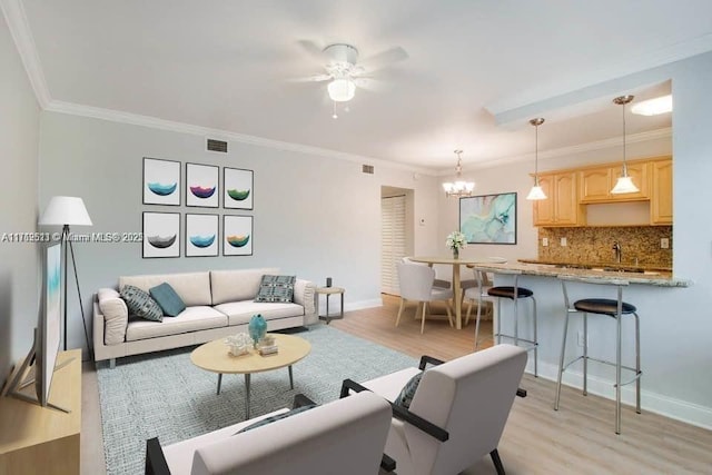 living room featuring light wood-type flooring, ceiling fan with notable chandelier, and ornamental molding