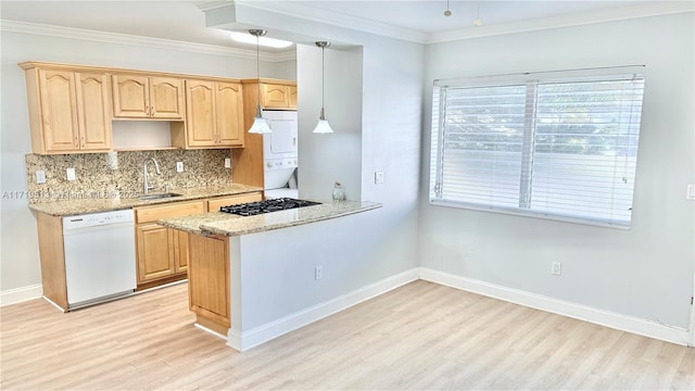 kitchen with pendant lighting, light brown cabinets, white dishwasher, sink, and light stone counters