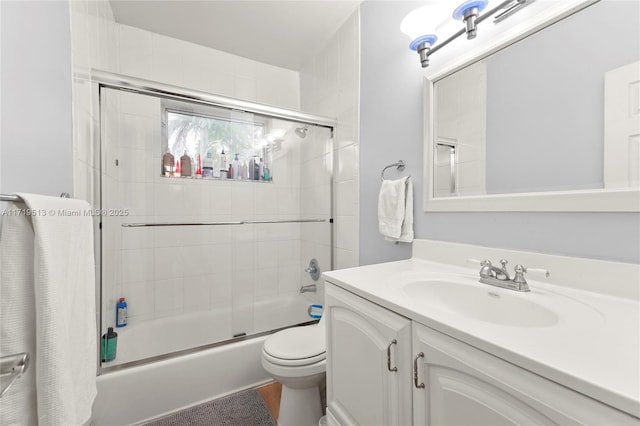 full bathroom with vanity, enclosed tub / shower combo, and toilet