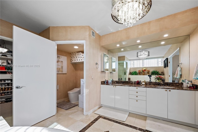 bathroom featuring tile patterned flooring, vanity, a chandelier, and toilet