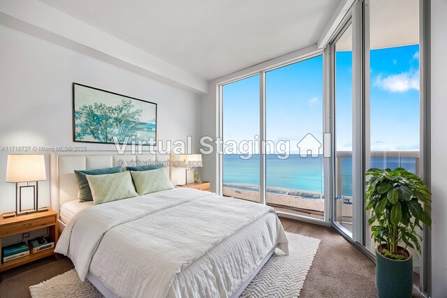 carpeted bedroom featuring a water view, floor to ceiling windows, a view of the beach, and access to outside