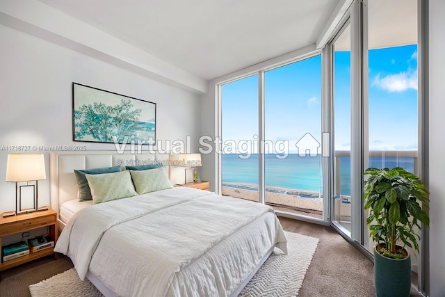 carpeted bedroom with a water view, expansive windows, and a beach view