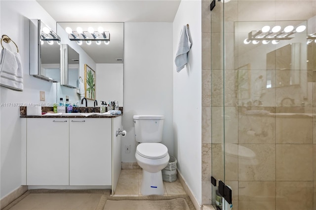 bathroom featuring vanity, tile patterned floors, toilet, and walk in shower