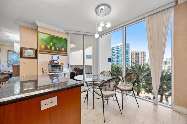 dining space featuring expansive windows, crown molding, and plenty of natural light