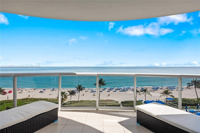 balcony featuring a beach view and a water view