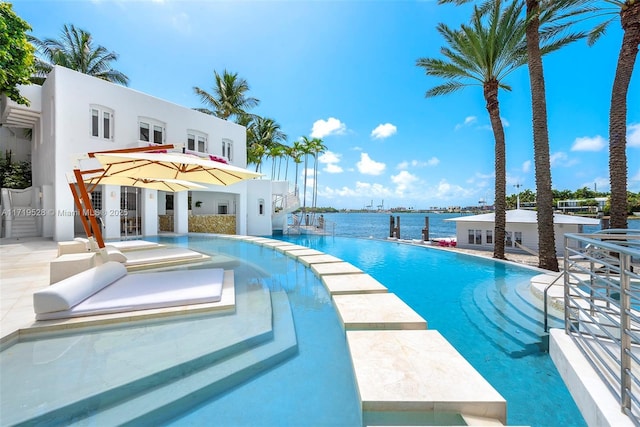 view of swimming pool with a water view and a patio area