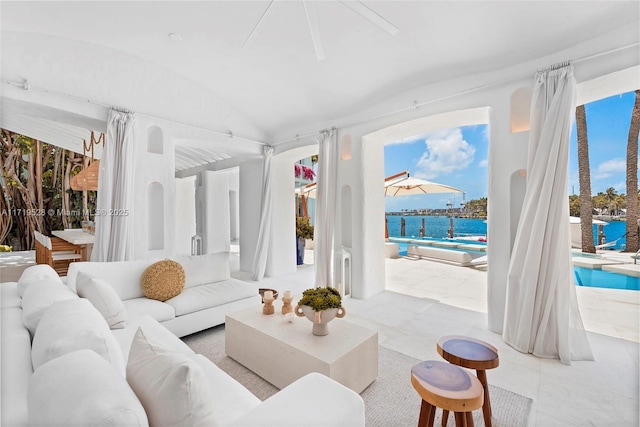 living room with a water view, a healthy amount of sunlight, and vaulted ceiling