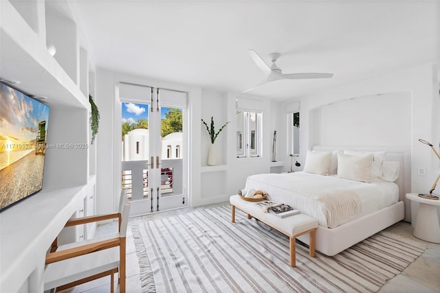 bedroom with access to exterior, french doors, and ceiling fan