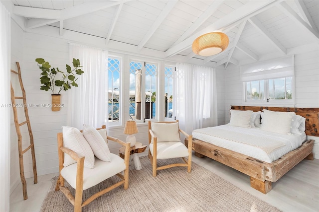 bedroom featuring vaulted ceiling with beams and wooden walls