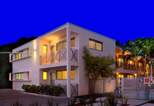 property exterior at night featuring a balcony