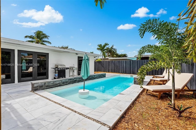 view of pool featuring a grill, french doors, and a patio