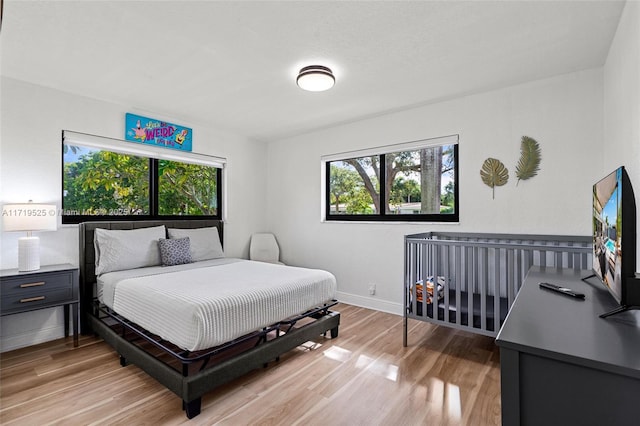 bedroom featuring light wood-type flooring and multiple windows