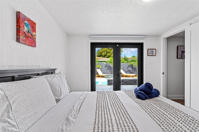 bedroom with a textured ceiling, access to outside, and french doors