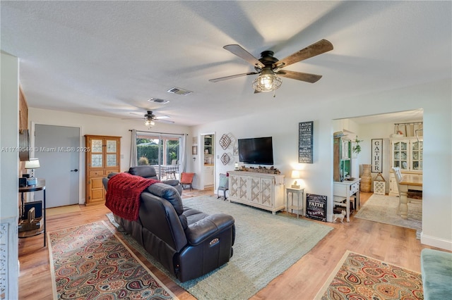 living room featuring ceiling fan and light hardwood / wood-style flooring