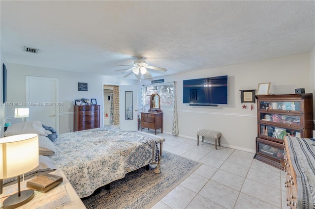 tiled bedroom with a textured ceiling and ceiling fan