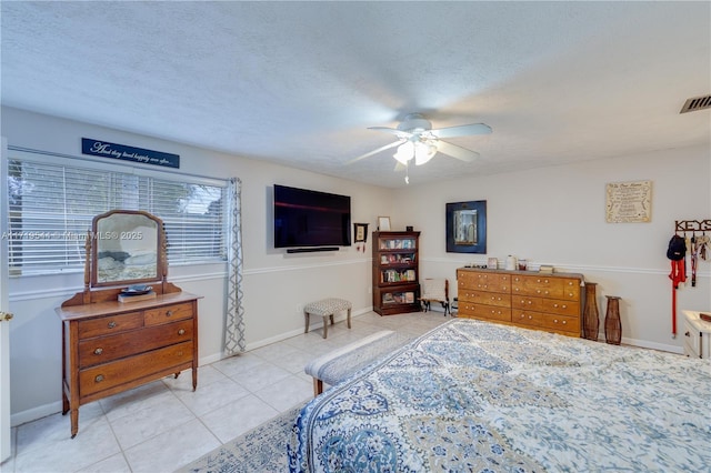 tiled bedroom featuring a textured ceiling and ceiling fan