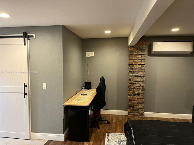 office area featuring hardwood / wood-style flooring, an AC wall unit, and a barn door