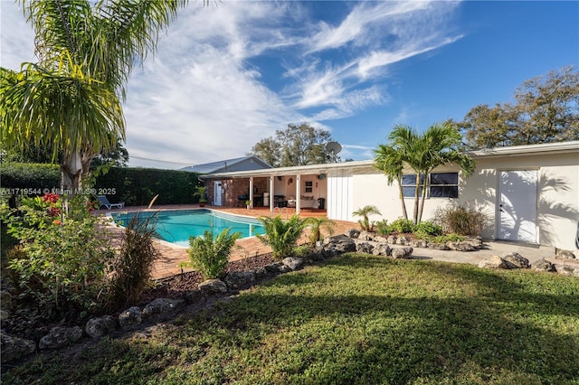 view of pool featuring a lawn and a patio area