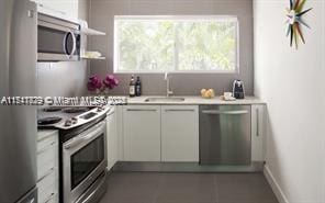 kitchen with white cabinets, stainless steel appliances, and sink