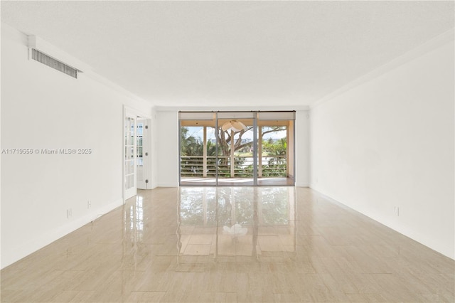 spare room featuring floor to ceiling windows and ornamental molding